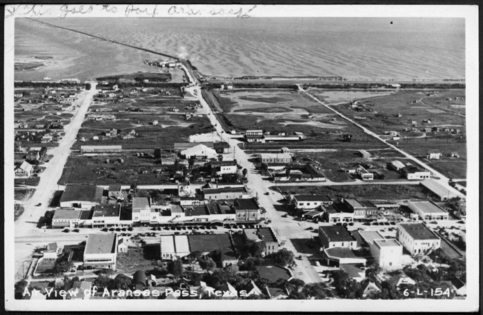 Aerial view of south Aransas Pass looking east toward the former Aransas Harbor Terminal Ry. right-of-way. Circa 1955. 