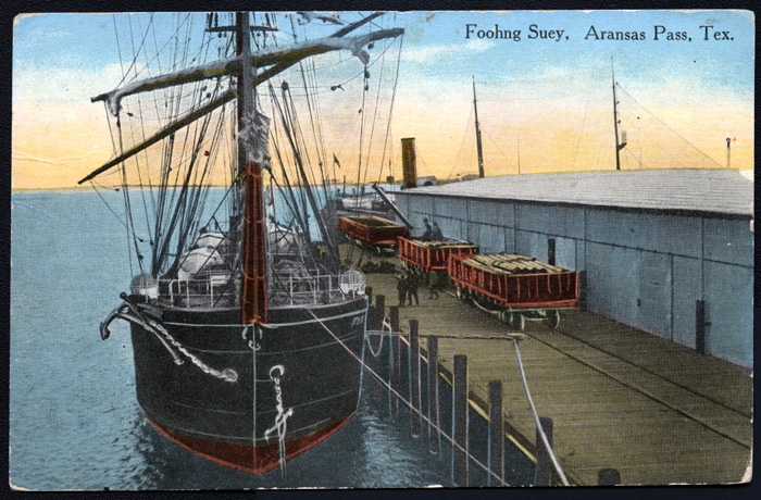Cargo sailboat "Foohng Suey" at the dock of the Aransas Pass Channel & Dock Company warehouse at Aransas Pass, Texas, ca. 1910's. 